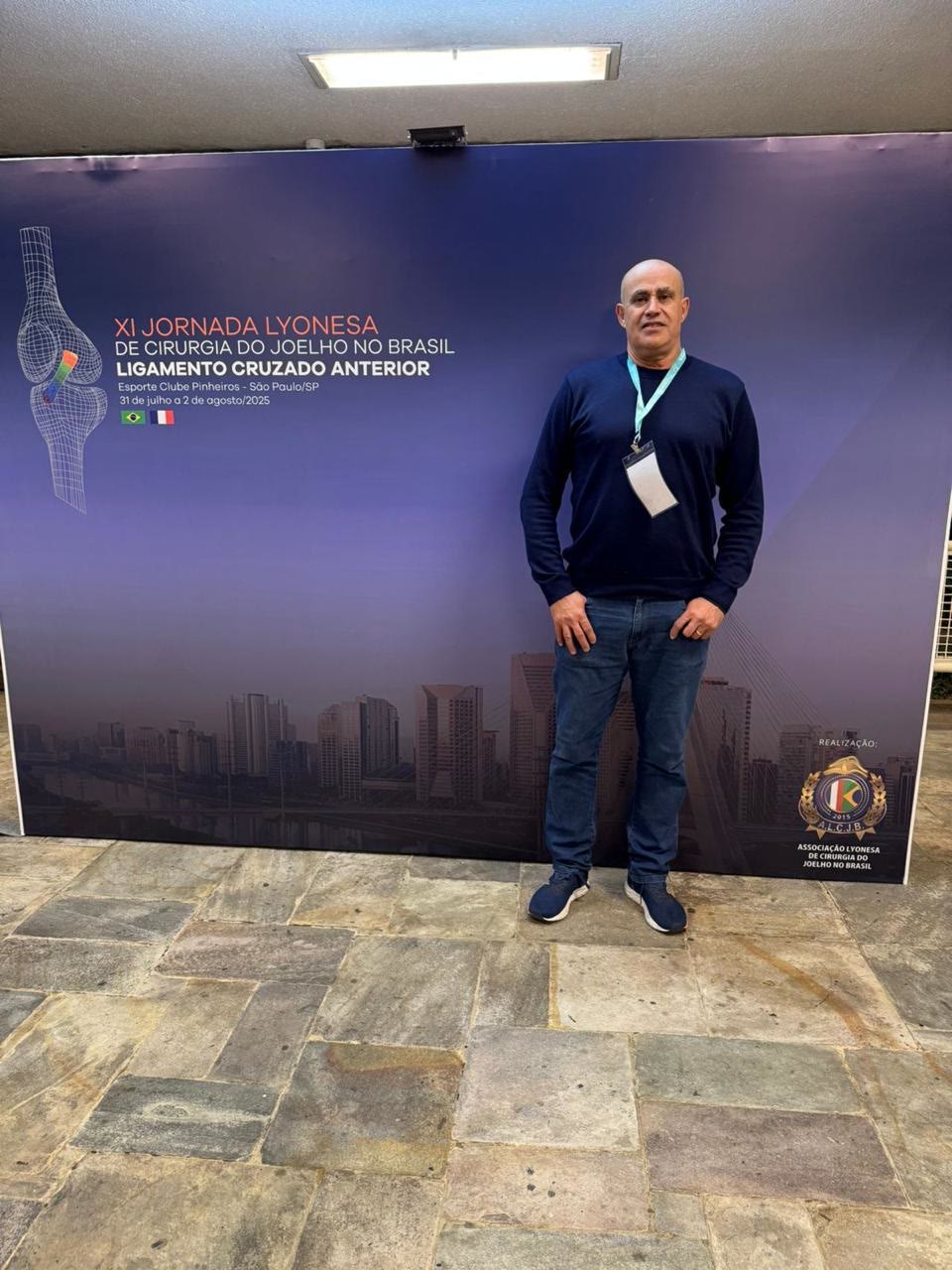 Dr. Nilton em frente ao painel da XI Jornada Lyonesa de Cirurgia do Joelho no Brasil