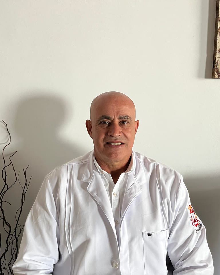 Retrato do Dr. Nilton Flavio da Silva, de jaleco branco, no consultório